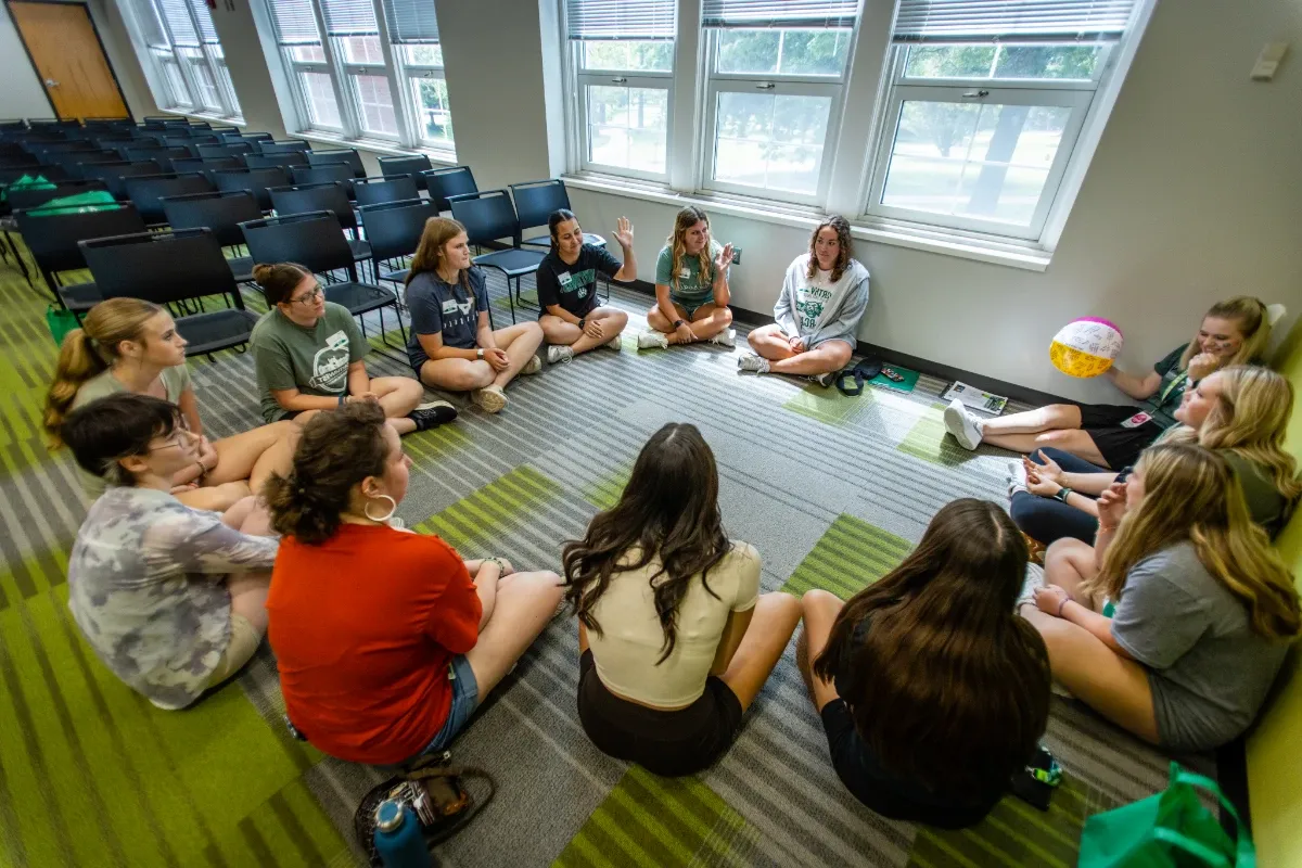 Students gather in a circle and participate in an icebreaker activity to get to know each other within their major groups.